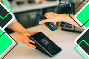 persona que se acerca a un teléfono móvil para efectuar un pago en una máquina de pago